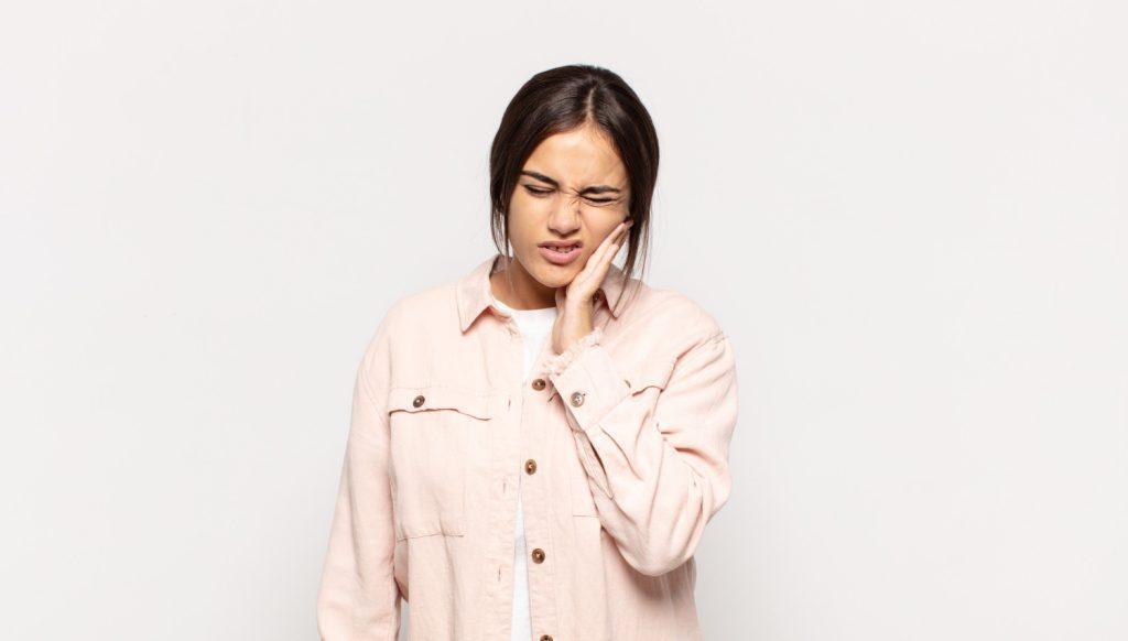 pretty-young-woman-holding-cheek-suffering-painful-toothache-feeling-ill-miserable-unhappy-looking-dentist