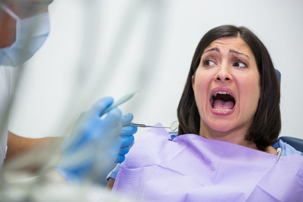 Female patient scared during a dental check-up in dental clinic