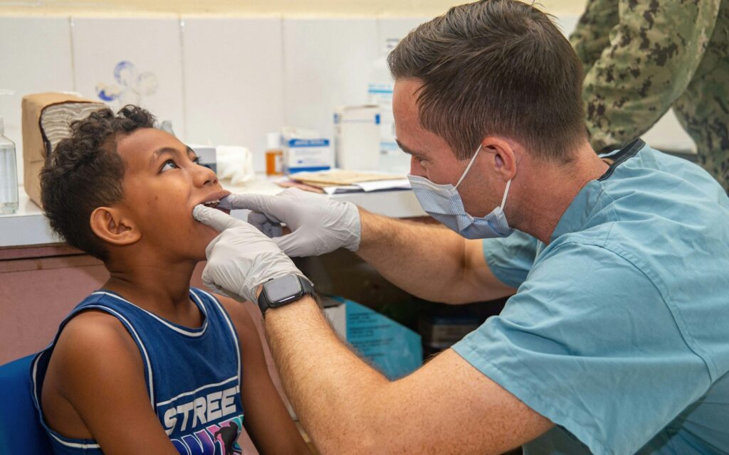 Dentist examining a young boy’s teeth during a back-to-school dental checkup