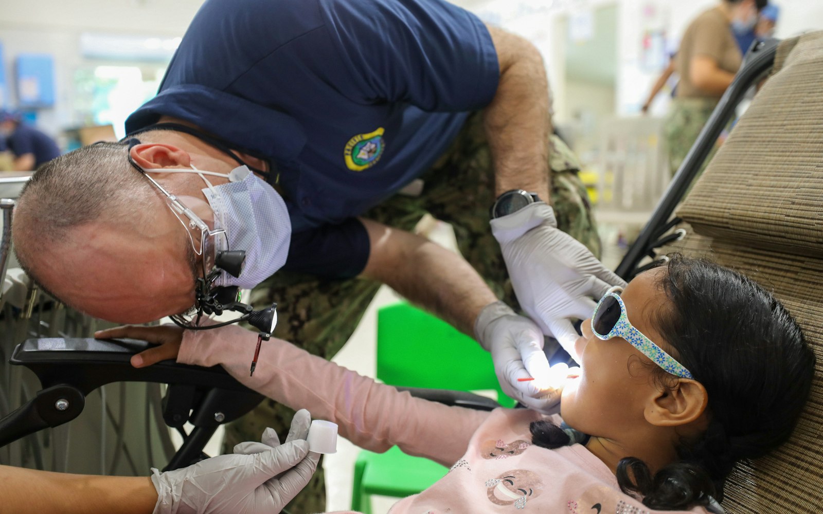 Dentist examining a young girl’s teeth for sealants and fluoride treatment