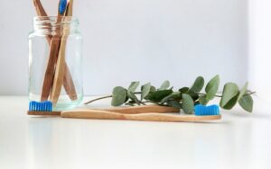 Blue and white toothbrush in a clear glass for daily oral care