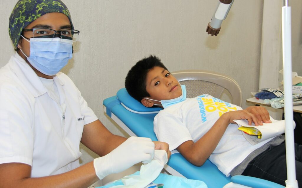Young boy getting his teeth checked before fall sports season