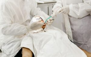 Two dentists in protective gear placing a tooth-colored filling